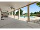 View of the patio columns, ceiling fans, stone siding and backyard pool area and perimeter fence at 3920 Ineal Dr, Cumming, GA 30028