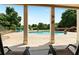 View of the backyard kidney-shaped pool from a patio with columns and two lounging chairs at 3920 Ineal Dr, Cumming, GA 30028