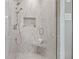 Modern shower with white marble tiling, a built-in niche, and glass door at 3920 Ineal Dr, Cumming, GA 30028