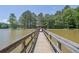 Wooden dock extending into a tranquil lake surrounded by lush trees at 4810 Duncans Lake Dr, Buford, GA 30519