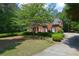 Brick home with black shutters, surrounded by green shrubs and shade trees at 4810 Duncans Lake Dr, Buford, GA 30519