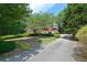 Red brick home featuring a long driveway with mature trees providing shade, and manicured shrubbery at 4810 Duncans Lake Dr, Buford, GA 30519