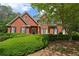 Charming two-story red brick home with mature landscaping, black shutters, and a welcoming entrance at 4810 Duncans Lake Dr, Buford, GA 30519