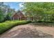 Charming two-story brick home featuring manicured landscaping, mature trees and lush greenery at 4810 Duncans Lake Dr, Buford, GA 30519
