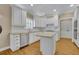 Well-lit kitchen with island, white cabinets, tiled backsplash, and stainless steel appliances at 4810 Duncans Lake Dr, Buford, GA 30519