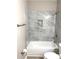 Clean bathroom featuring tiled tub, toilet, and brushed-metal hardware at 5091 Newark Ave, Clarkdale, GA 30111