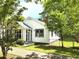 Charming white cottage home with inviting screened porch and well-maintained landscaping at 5091 Newark Ave, Clarkdale, GA 30111