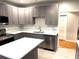 Gray kitchen cabinets, stainless appliances, stone counter tops, and a breakfast bar at 5091 Newark Ave, Clarkdale, GA 30111