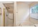 Bathroom featuring a tub with gold-trimmed shower doors and a window allowing natural light at 512 Antler Ln, Suwanee, GA 30024
