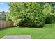 View of a fenced backyard with lush lawn and mature trees, perfect for outdoor enjoyment at 5244 Carrington Park Dr, Powder Springs, GA 30127