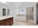 Bathroom featuring dual sinks, a soaking tub, and a glass-enclosed shower at 5244 Carrington Park Dr, Powder Springs, GA 30127