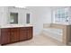 Bright bathroom featuring dual sinks, a soaking tub, and a separate shower at 5244 Carrington Park Dr, Powder Springs, GA 30127