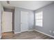 A simple bedroom with grey walls, laminate flooring, and a window for natural light at 5244 Carrington Park Dr, Powder Springs, GA 30127
