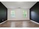 Bright bedroom with wood flooring, two windows, and freshly painted walls at 5244 Carrington Park Dr, Powder Springs, GA 30127