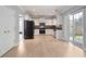 Modern kitchen with stainless steel appliances, white cabinets, hardwood-style floors and sliding glass door at 5244 Carrington Park Dr, Powder Springs, GA 30127