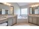 Bright bathroom showcasing dual vanities with granite countertops and a soaking tub by a window at 12084 Cotton Aly, Alpharetta, GA 30009