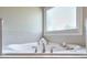 A large soaking tub with chrome fixtures and a view from the window is a relaxing escape at 12084 Cotton Aly, Alpharetta, GA 30009