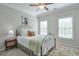 Cozy bedroom with a decorative iron bed frame, complemented by a ceiling fan and two windows at 12084 Cotton Aly, Alpharetta, GA 30009