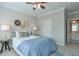 Comfortable bedroom featuring ceiling fan, stylish decor, and glimpse into the attached bathroom at 12084 Cotton Aly, Alpharetta, GA 30009