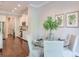 Bright dining area featuring a glass table with seating for four and a view into the kitchen at 12084 Cotton Aly, Alpharetta, GA 30009