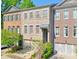 Charming townhome with well-manicured landscaping, attached garages, and a welcoming, brick facade at 12084 Cotton Aly, Alpharetta, GA 30009