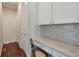 Compact office nook with custom cabinetry, a built-in desk, and a stylish mosaic tile backsplash at 12084 Cotton Aly, Alpharetta, GA 30009