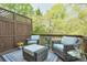 Cozy outdoor patio featuring comfortable seating, a privacy fence, and a view of the surrounding greenery at 12084 Cotton Aly, Alpharetta, GA 30009