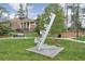 Outdoor sculpture on a grassy lawn with trees, and a nearby gazebo, enhancing the community's artistic appeal at 12084 Cotton Aly, Alpharetta, GA 30009