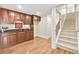 Basement bar area featuring custom wood cabinets, granite countertops, and hardwood floors adjacent to carpeted stairs at 198 Grandmar Chase, Canton, GA 30115
