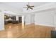 Open-concept living room with hardwood floors, ceiling fan, and seamless flow to the kitchen area at 198 Grandmar Chase, Canton, GA 30115