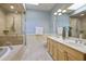 Luxurious bathroom featuring dual sinks, a soaking tub, and a glass-enclosed shower at 273 12Th Ne St # 421, Atlanta, GA 30309