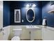 Bathroom featuring a pedestal sink, oval mirror, and crisp, navy blue walls at 273 12Th Ne St # 421, Atlanta, GA 30309