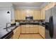 Well-lit kitchen with stainless steel appliances, black countertops, and wood cabinets at 273 12Th Ne St # 421, Atlanta, GA 30309