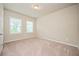 This bedroom features neutral carpeting and paint, with natural light from the two windows at 2927 Dolostone Way, Dacula, GA 30019