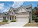 Charming two-story brick house with a covered front porch and an attached two-car garage on a sunny day at 2927 Dolostone Way, Dacula, GA 30019