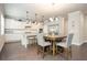 Bright eat-in kitchen with stainless appliances, white cabinets, granite counters, island with seating and hardwood floors at 2927 Dolostone Way, Dacula, GA 30019