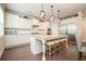 Bright eat-in kitchen with stainless appliances, white cabinets, granite counters, island with seating and hardwood floors at 2927 Dolostone Way, Dacula, GA 30019
