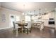 Open concept kitchen with an island, breakfast bar, white cabinets, and a dining area at 2927 Dolostone Way, Dacula, GA 30019