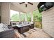 Relaxing covered porch with comfortable seating, an outdoor fireplace, and a wooded view at 2927 Dolostone Way, Dacula, GA 30019