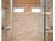 Modern walk-in shower featuring a tiled wall, dual shower heads, glass doors, and windows for natural light at 2927 Dolostone Way, Dacula, GA 30019