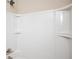 White shower unit with built-in shelving and a brushed nickel shower head at 2927 Dolostone Way, Dacula, GA 30019