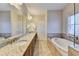 Luxurious bathroom featuring double sinks, a soaking tub, and a large mirror at 4892 Kentwood Dr, Marietta, GA 30068