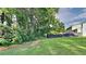 Lush backyard with green grass, mature trees, and a view of the home for outdoor enjoyment at 5326 Nader Pl, Stone Mountain, GA 30088