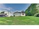 Spacious backyard with lush lawn, perimeter trees, and a view of the home's exterior at 5326 Nader Pl, Stone Mountain, GA 30088