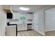 Modern kitchen with white cabinets, stainless steel appliances, and laminate flooring at 5326 Nader Pl, Stone Mountain, GA 30088