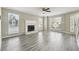Bright living room featuring wood-look flooring, a fireplace, and multiple windows at 360 Wynbrook Dr, Mcdonough, GA 30253