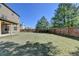 Large grassy backyard enclosed by a wooden fence and mature trees at 556 Georgia Cir, Loganville, GA 30052
