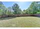 Large grassy backyard enclosed by a wooden fence and mature trees at 556 Georgia Cir, Loganville, GA 30052