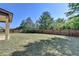 Large grassy backyard enclosed by a wooden fence and mature trees at 556 Georgia Cir, Loganville, GA 30052