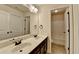 Bathroom featuring a double vanity with mirror, lighting, dark cabinets, and tile flooring at 556 Georgia Cir, Loganville, GA 30052